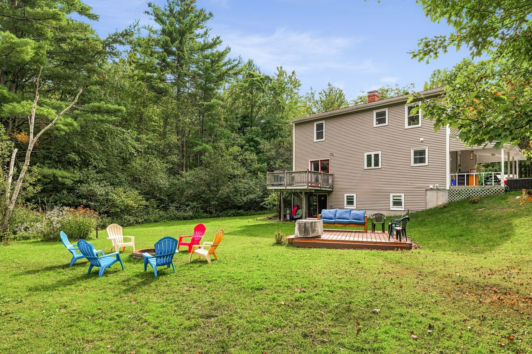 The back of the house from the lawn, with the deck, the walkout lower level, and the fire pit chairs