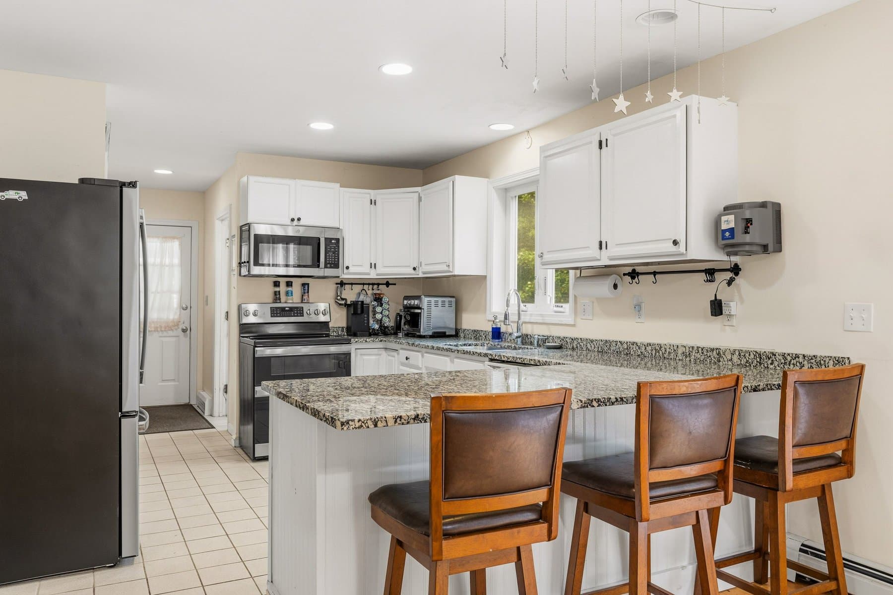 The granite peninsula with 3 stools, open to the living room