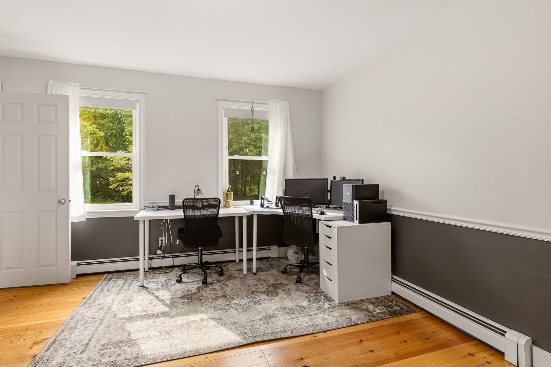 The front room set up as an office, with 2 windows and the wide pine floor